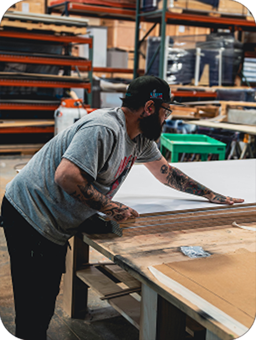 Worker sanding wood in fabrication facility