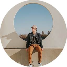 Man posing inside large outdoor circular frame