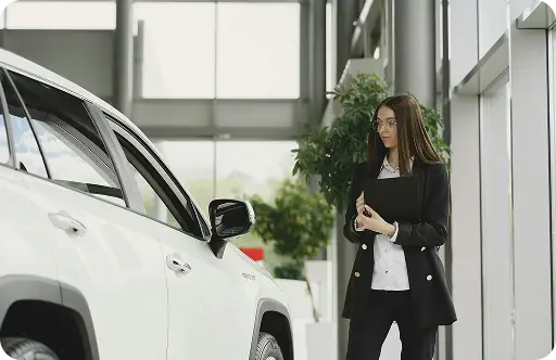 Woman walking near white car on city sidewalk
