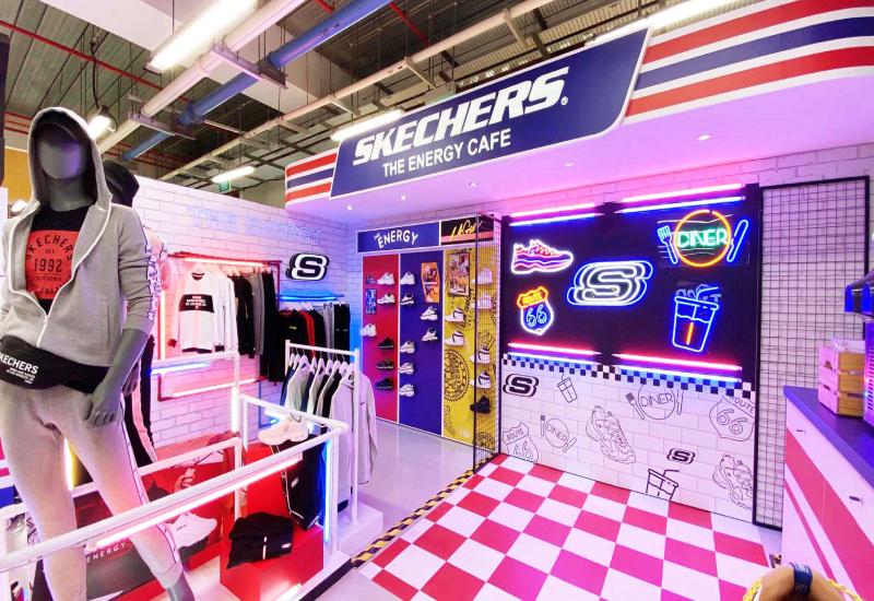 Vibrant Skechers retail display called “The Energy Cafe” featuring neon signs, mannequins, and colorful product showcases.