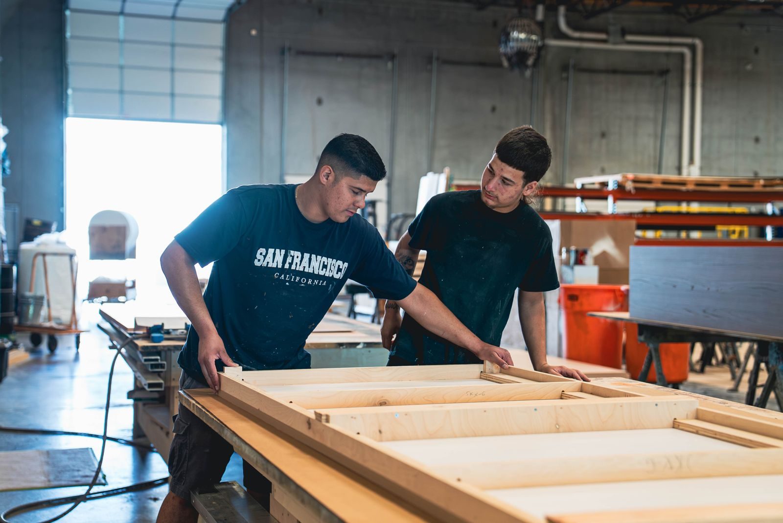 Steadfast builders inspecting exhibit components at a workbench